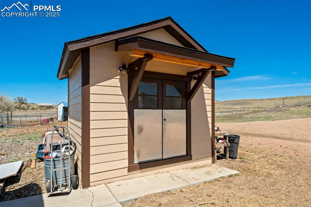 Image 45 of 50: View of outbuilding with fence and an outdoor structure