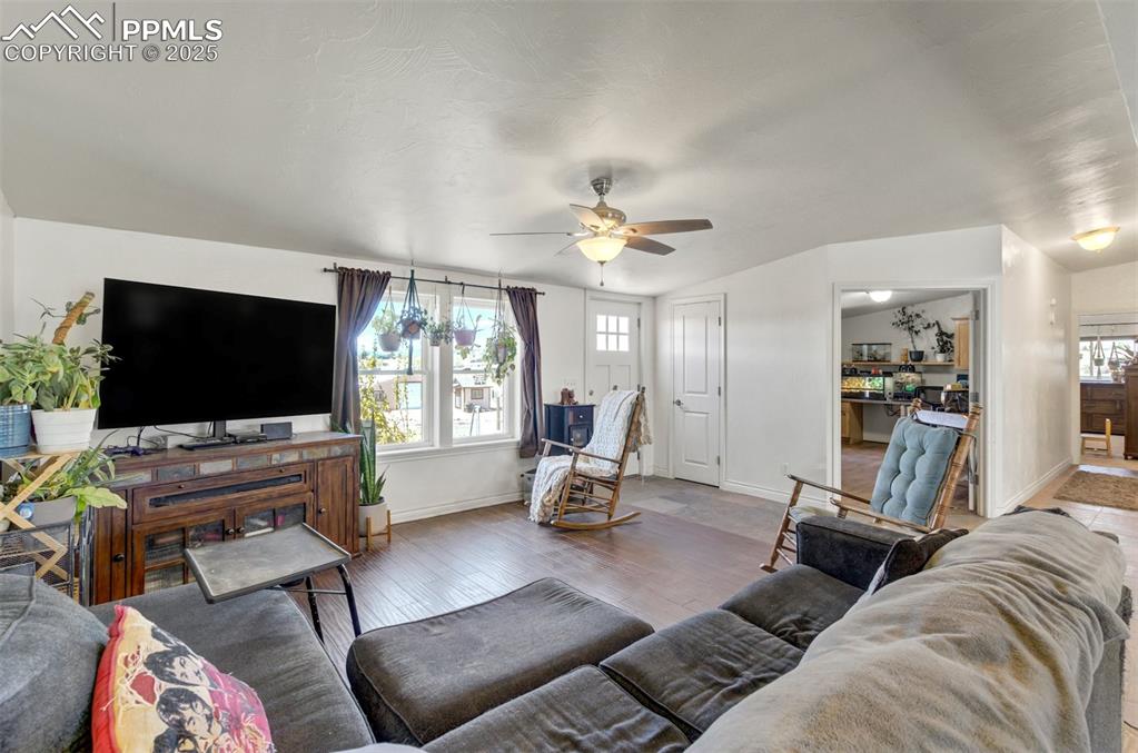 Image 7 of 50: Living room with baseboards, ceiling fan, a healthy amount of sunlight, and