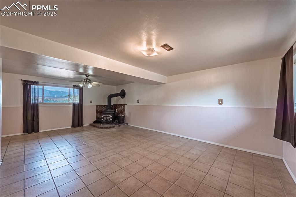 Image 12 of 31: stove, ceiling fan, and light tile patterned flooring