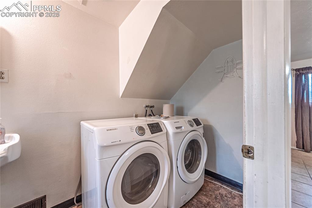Image 16 of 31: Laundry area with washer and clothes dryer
