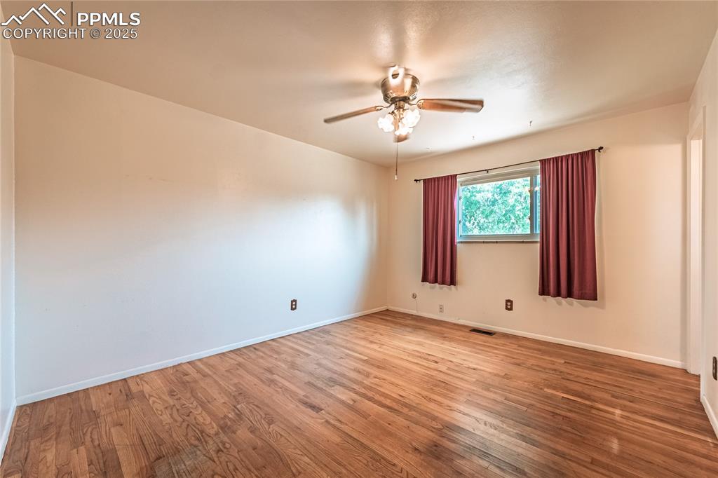 Image 22 of 31: wood finished floors and ceiling fan