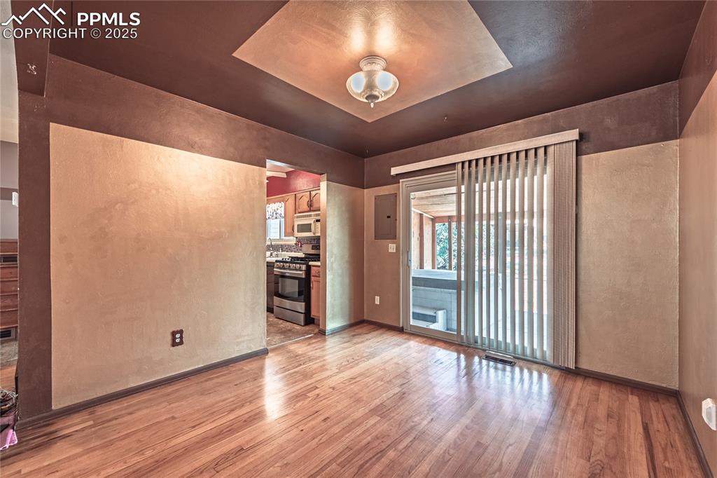 Image 23 of 31: Spare room with a textured wall, light wood-style flooring, a tray ceiling,