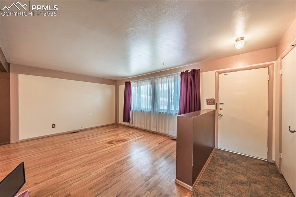 Image 6 of 31: Entrance foyer with wood finished floors and baseboards