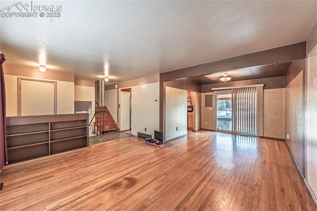 Image 8 of 31: Basement featuring light wood finished floors, stairway, and electric panel