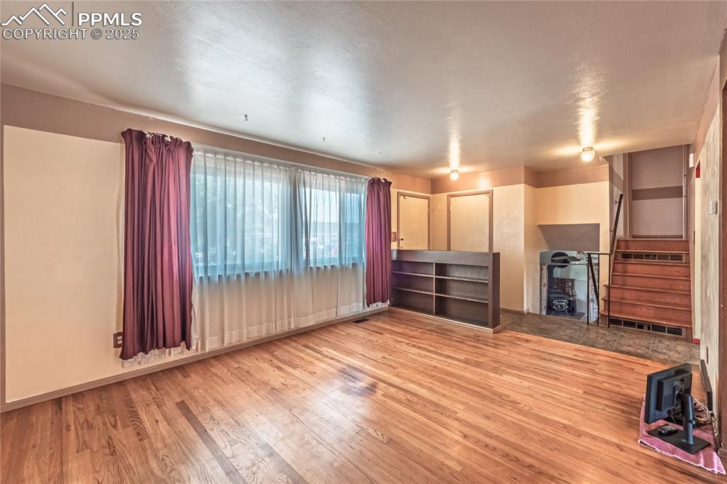 Image 9 of 31: living room with light wood finished floors and stairway