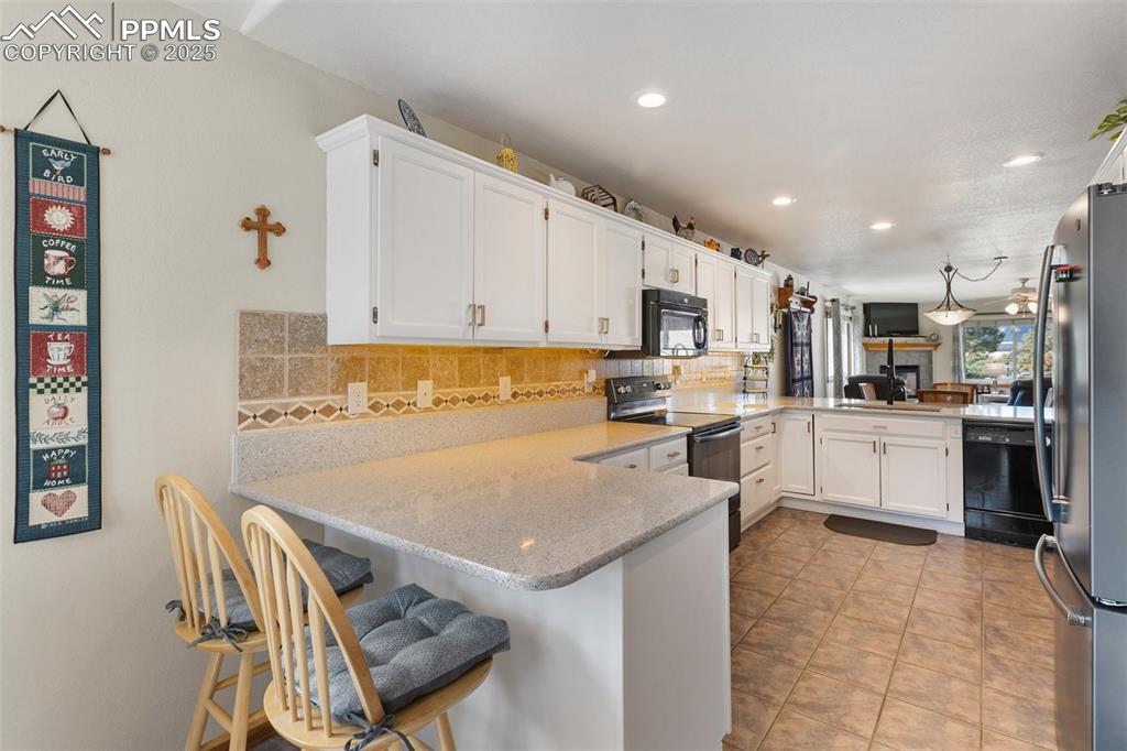 Image 5 of 43: Kitchen with breakfast bar and quartz counter tops
