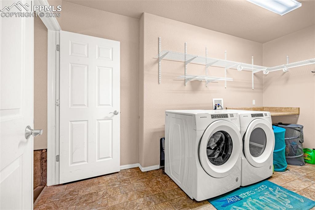 Image 12 of 40: Utility room featuring neutral wall tones and tile-look flooring