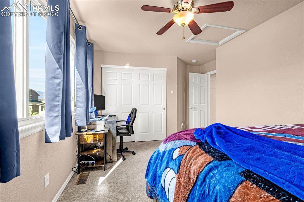 Image 13 of 40: Bedroom featuring large windows, carpet flooring, a ceiling fan with integr