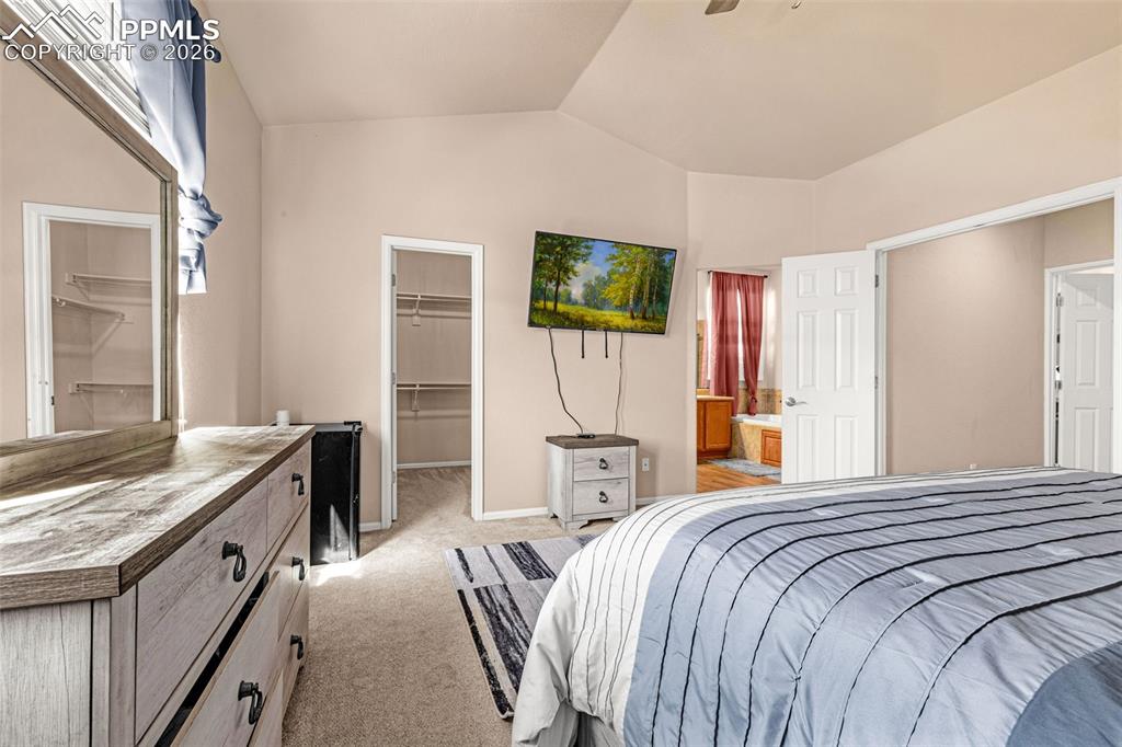 Image 18 of 40: Spacious carpeted room featuring vaulted ceilings and neutral wall tones