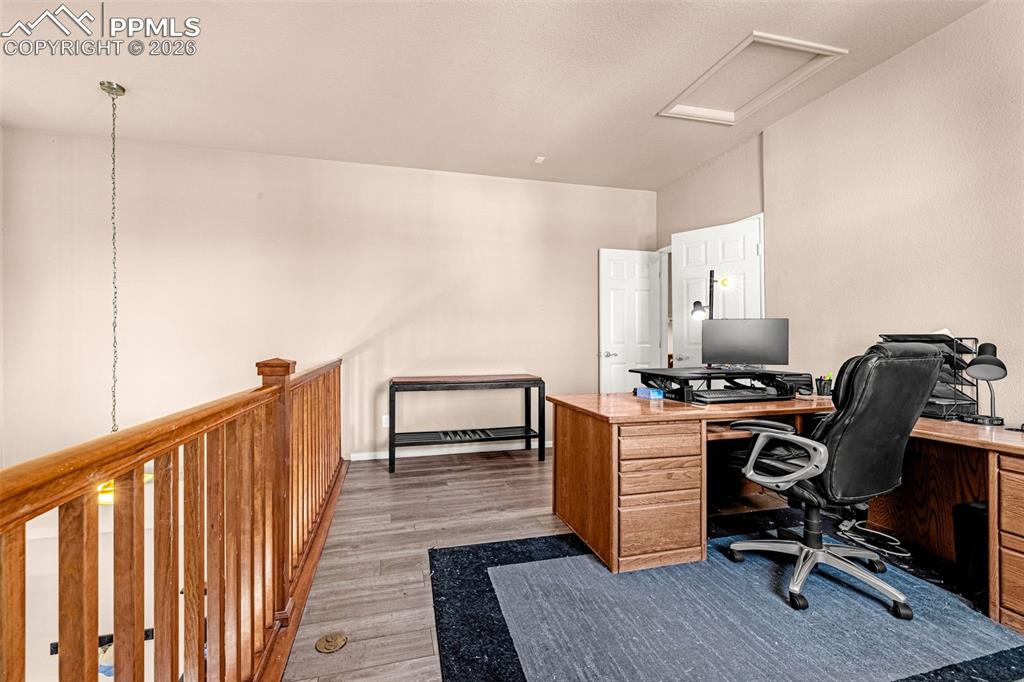 Image 19 of 40: Versatile upper-level space featuring wood-finish flooring, a wood railing,