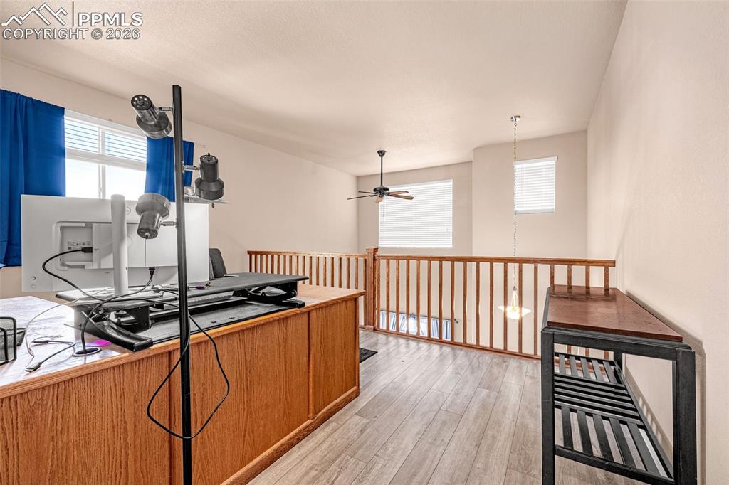 Image 20 of 40: Open loft area featuring wood-finish flooring, light-toned walls, and multi