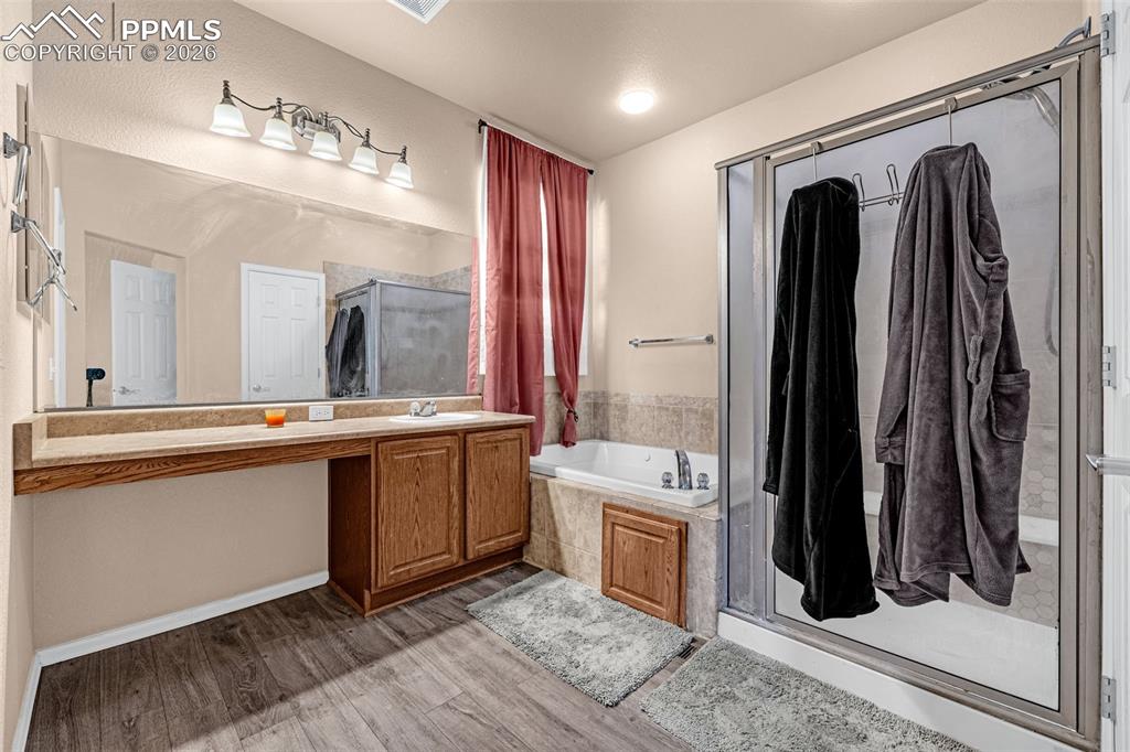 Image 21 of 40: Bathroom featuring wood-finish flooring, a vanity with a light-toned counte
