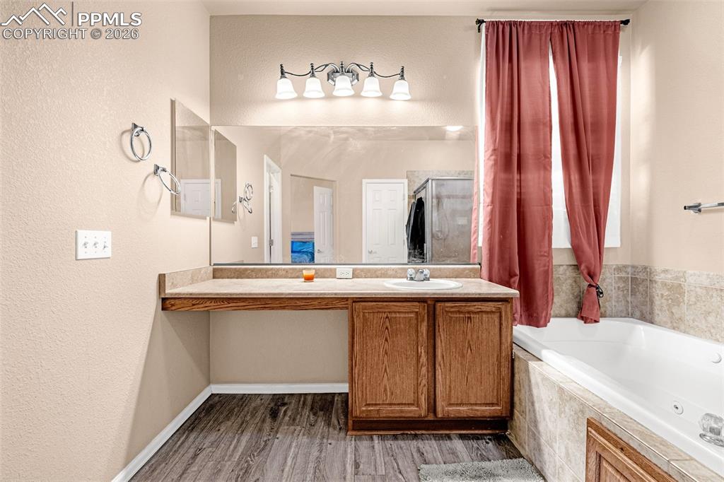 Image 23 of 40: Bathroom featuring a built-in vanity with a light-colored countertop, integ