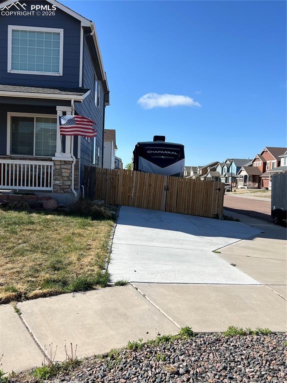 Image 3 of 3: The property features a blue exterior with white trim and a stone accent co