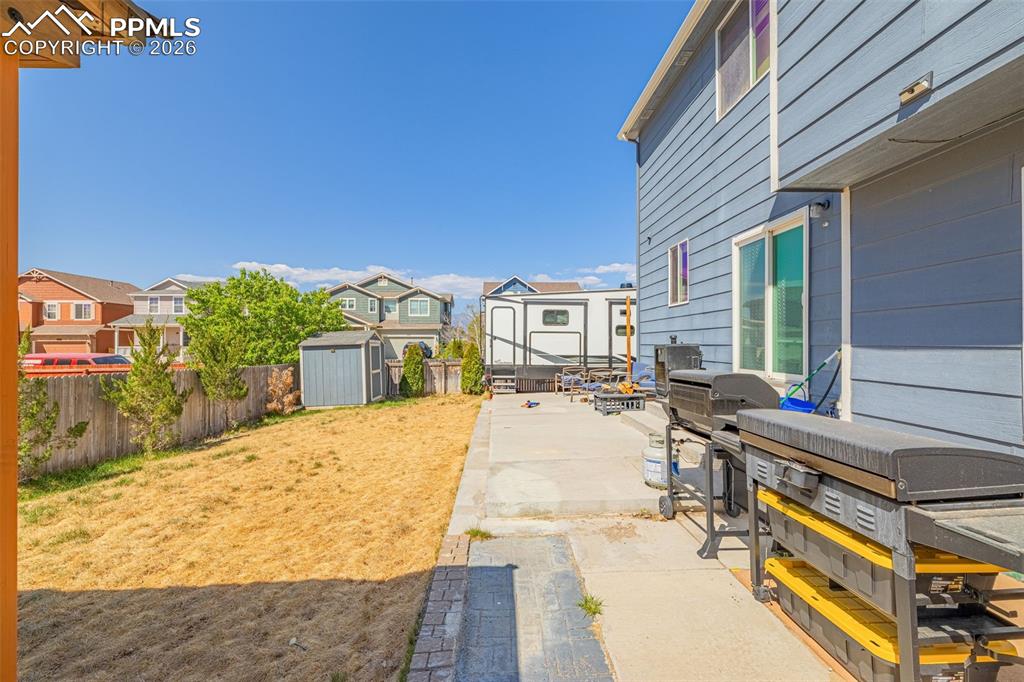 Image 30 of 40: Expansive backyard featuring a concrete patio, a storage shed, and a privac