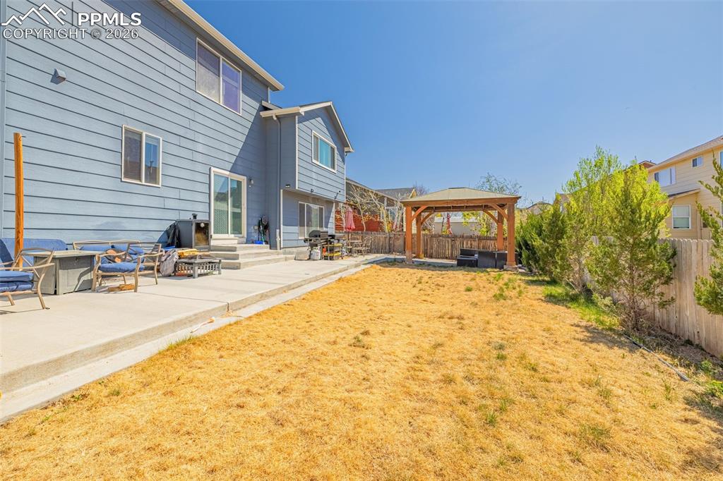 Image 32 of 40: Expansive backyard featuring a concrete patio, a multi-level concrete slab,