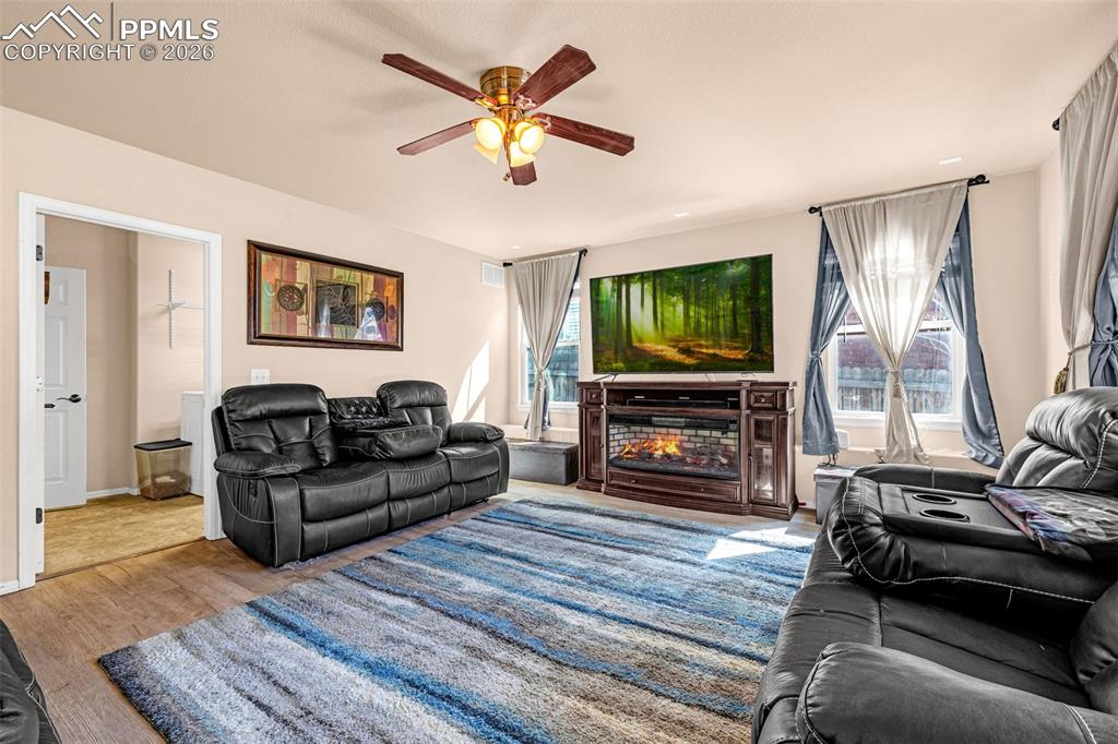 Image 6 of 40: Living area featuring wood-finish flooring, a ceiling fan with integrated l