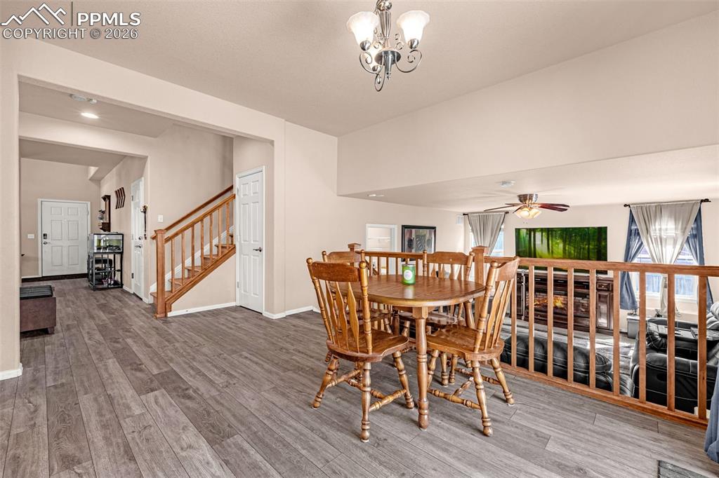 Image 8 of 40: Open-concept dining area featuring wood-finish flooring, a decorative chand