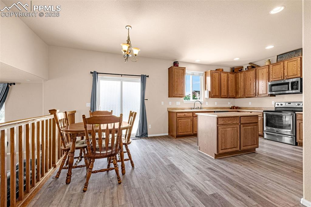 Image 9 of 40: Kitchen and dining area featuring wood-finish flooring, a kitchen island, s