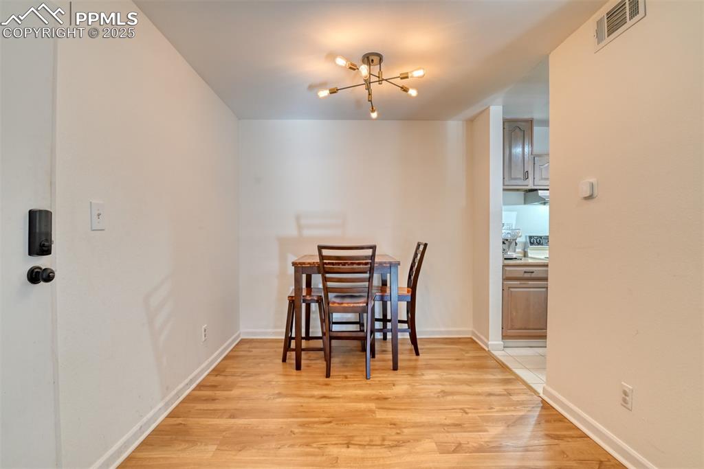 Image 12 of 31: Dining area with a chandelier and light wood-style flooring