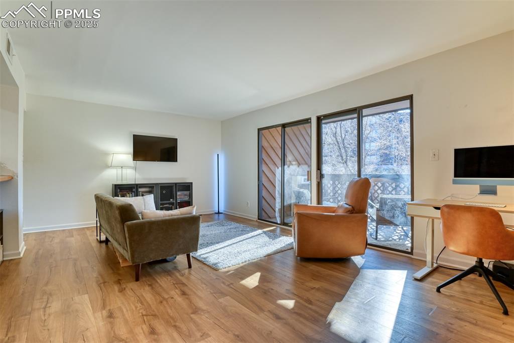 Image 13 of 31: Living area with light wood finished floors and an office area