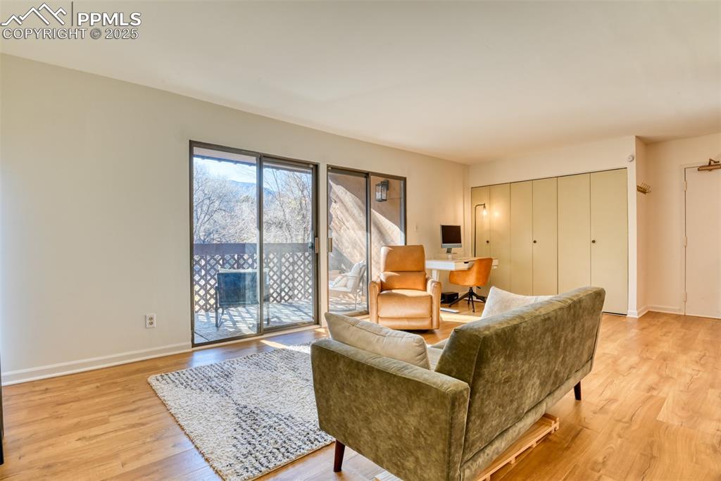 Image 18 of 31: Living room with an office area and light wood finished floors