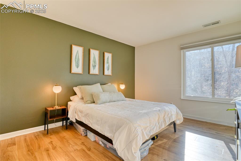 Image 23 of 31: Bedroom with light wood finished floors and baseboards