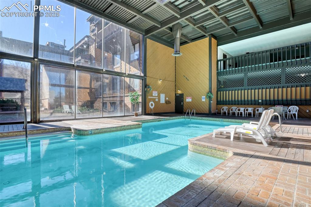 Image 30 of 31: Indoor community pool featuring a patio