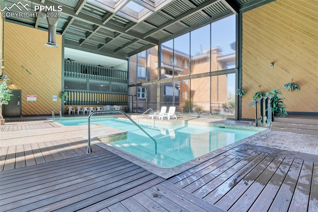 Image 31 of 31: Indoor community pool featuring a patio area and a deck