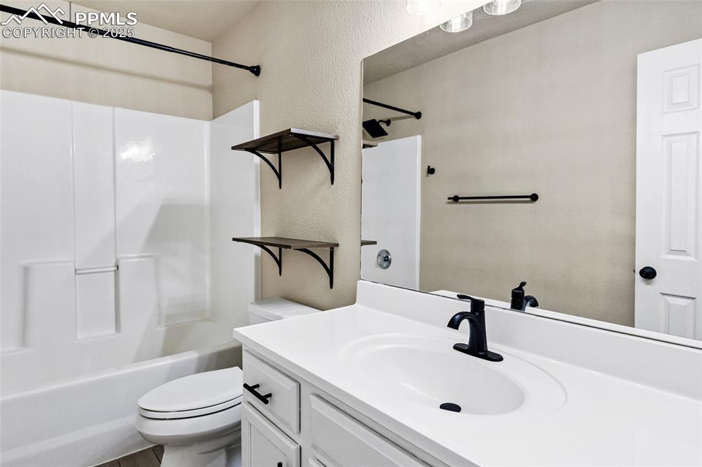 Image 12 of 22: Bathroom with a textured wall, vanity, and bathing tub / shower combination