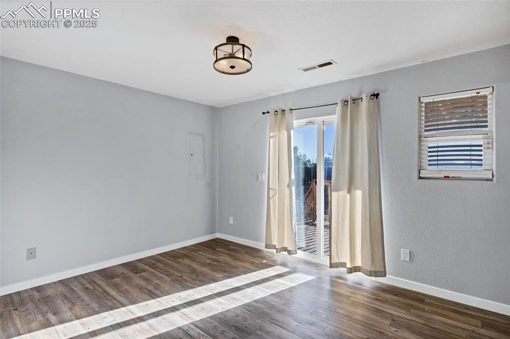 Image 15 of 22: Empty room with baseboards and dark wood finished floors