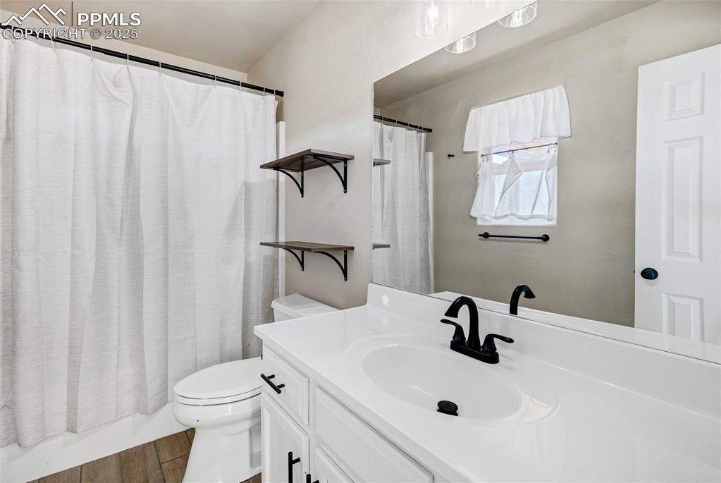 Image 18 of 22: Bathroom featuring vanity, shower / bathtub combination with curtain, and d