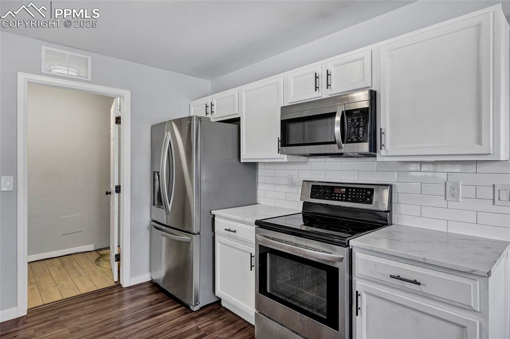 Image 9 of 22: Kitchen featuring appliances with stainless steel finishes, dark wood-style