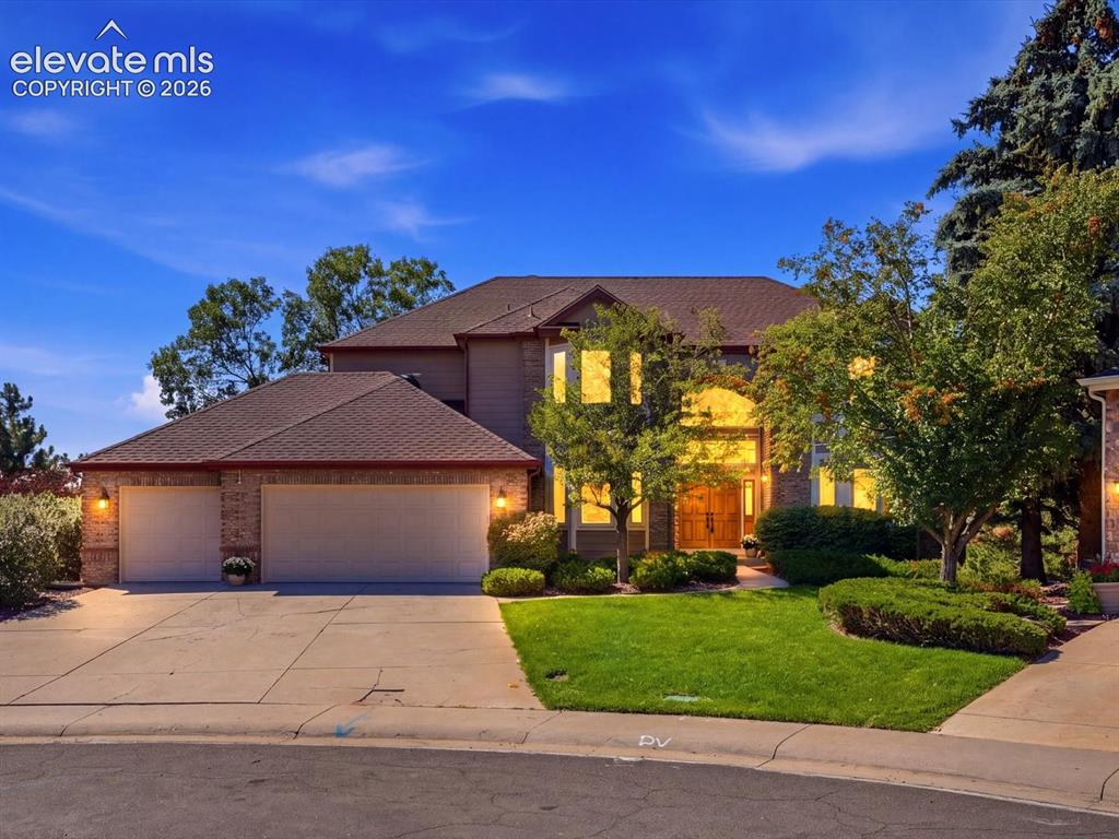 Caption: Two-story residence featuring a brick and siding exterior, multi-pitched roofline, three-car garage,