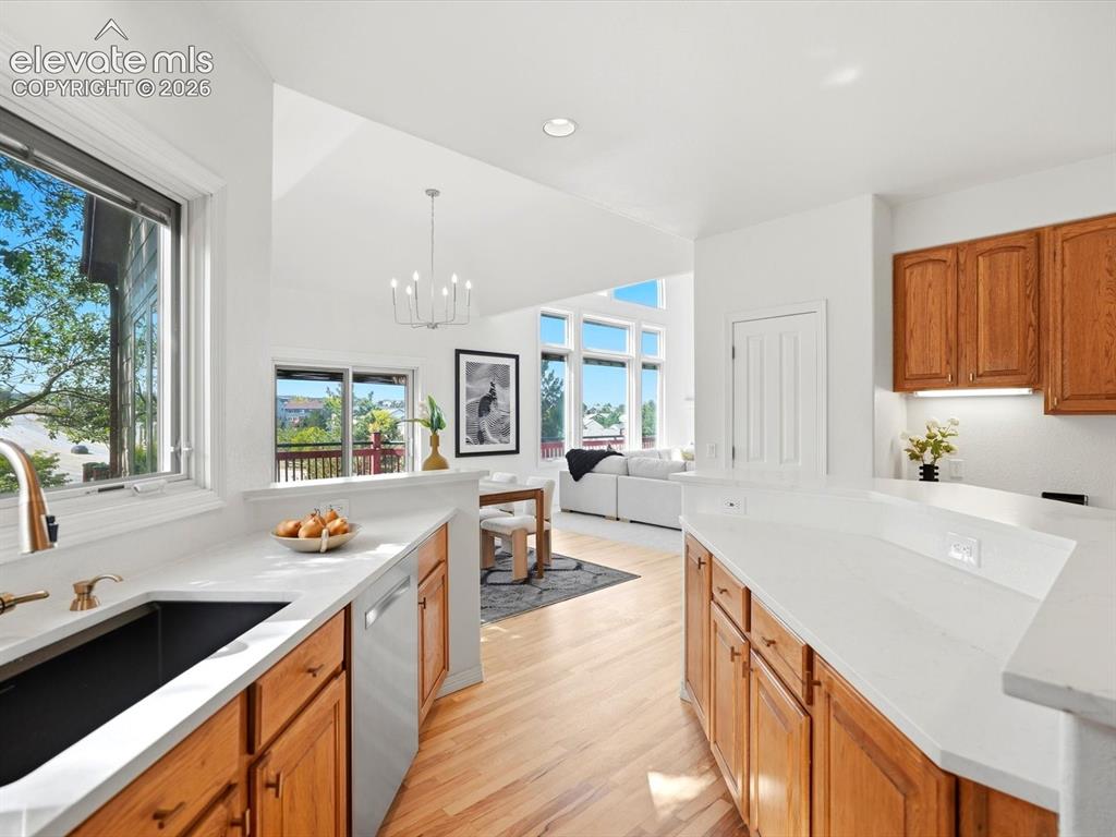 Image 11 of 48: Kitchen featuring wood cabinetry, white countertops, a deep-basin sink with