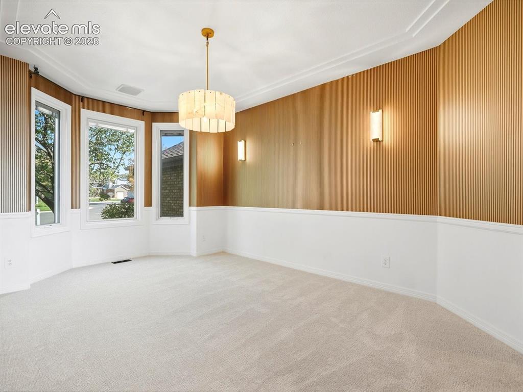 Image 17 of 48: Room featuring bay windows, vertical wood-panelled accent walls, wainscotin