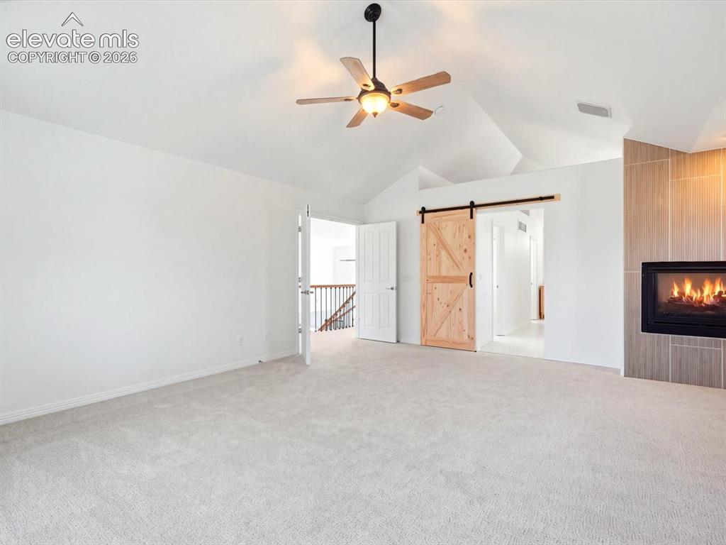 Image 27 of 48: Vaulted ceilings, built-in fireplace with neutral tile surround, wooden bar