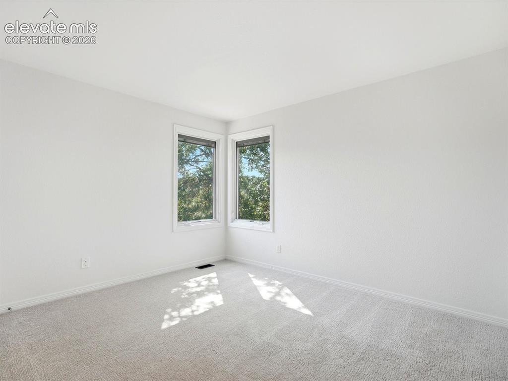 Image 32 of 48: Neutral-toned wall-to-wall carpeting and dual corner windows