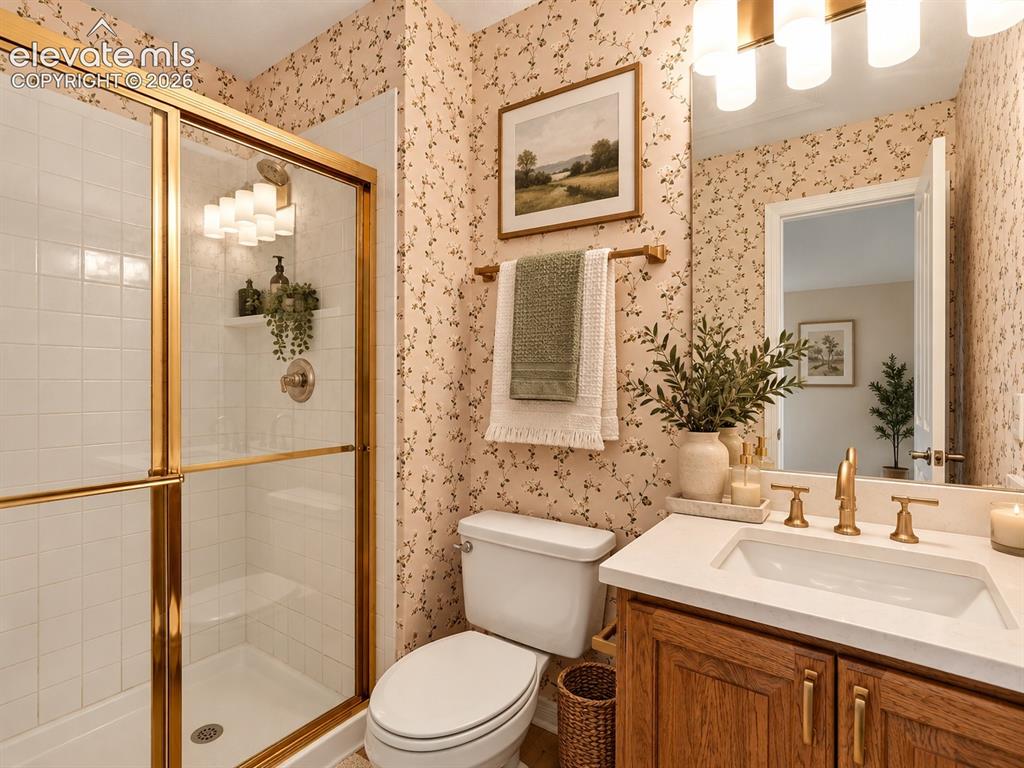 Image 33 of 48: Bathroom featuring a vanity with a white solid-surface countertop, an under