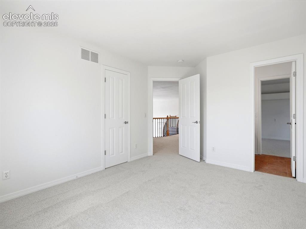 Image 34 of 48: Interior space featuring neutral carpeting, white walls, six-panel interior
