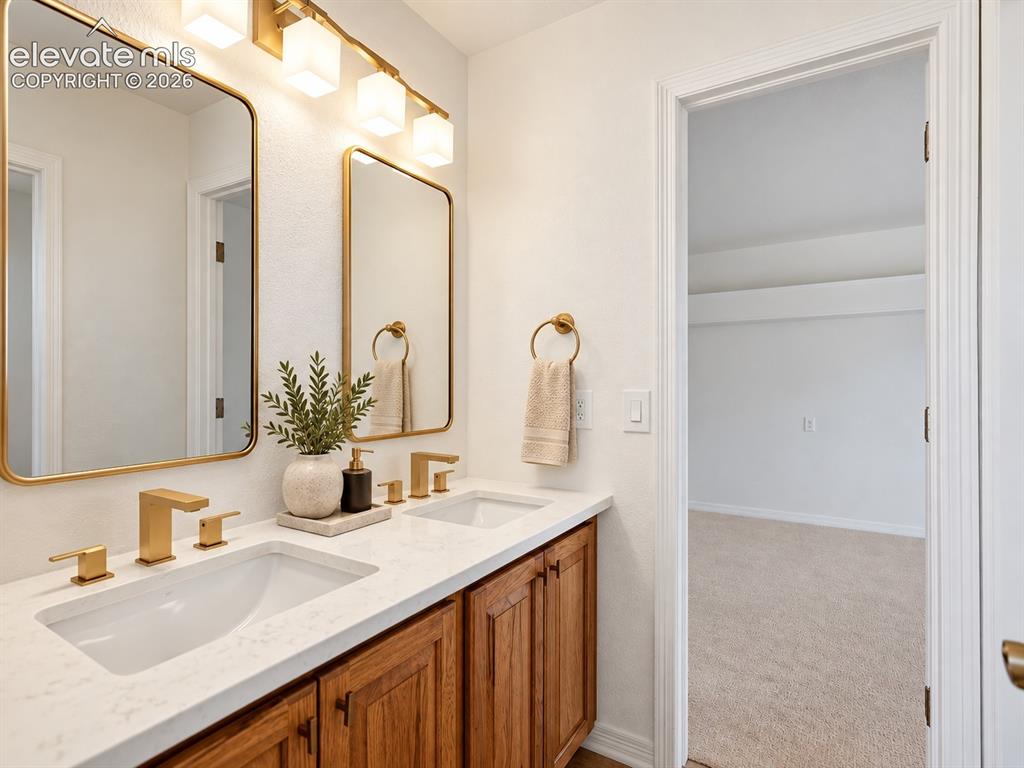 Image 35 of 48: Dual-sink vanity featuring stone-patterned countertops, wood-finish cabinet
