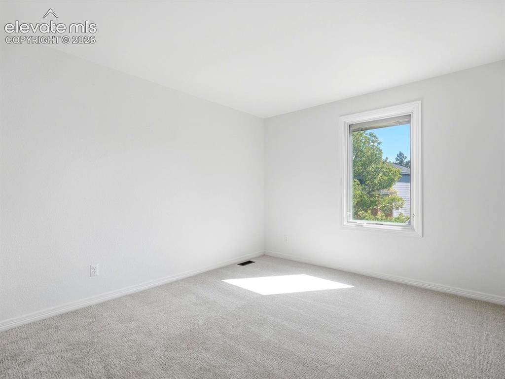Image 36 of 48: Neutral-toned wall-to-wall carpeting and single-pane window with white trim