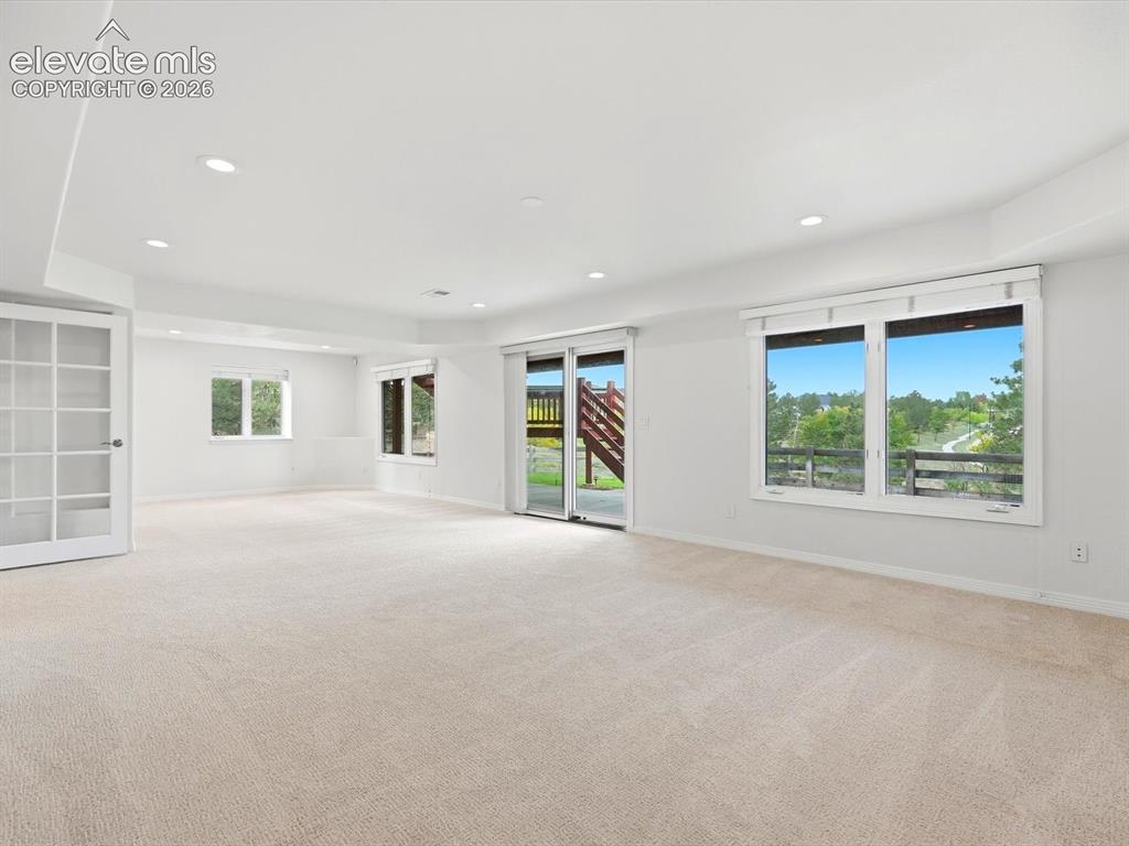Image 39 of 48: Open interior space featuring neutral carpeting, recessed ceiling lighting,