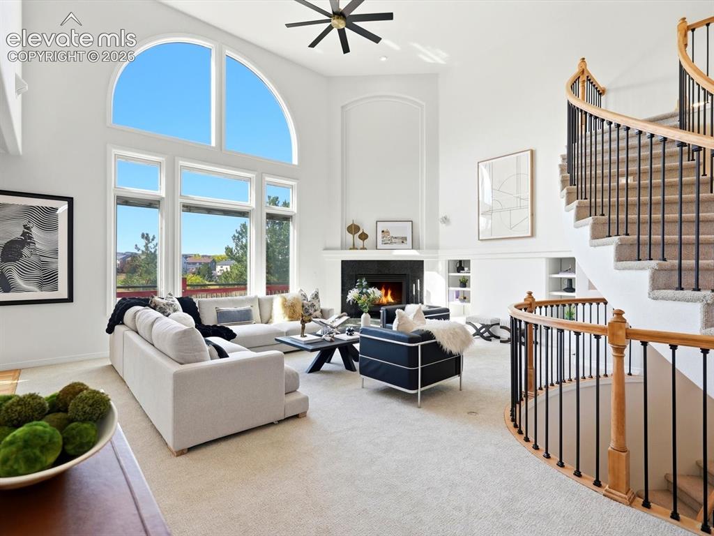 Image 4 of 48: Two-story living area featuring a vaulted ceiling, floor-to-ceiling arched