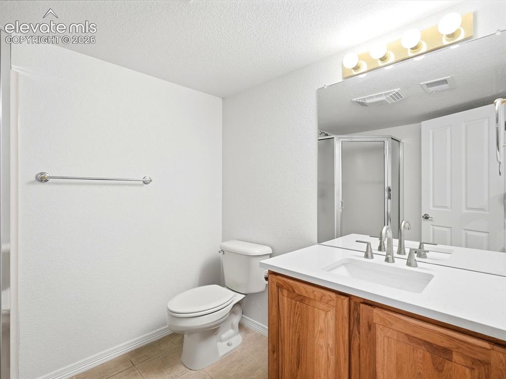 Image 42 of 48: Bathroom vanity featuring a light-toned countertop, undermount sink, wood-f