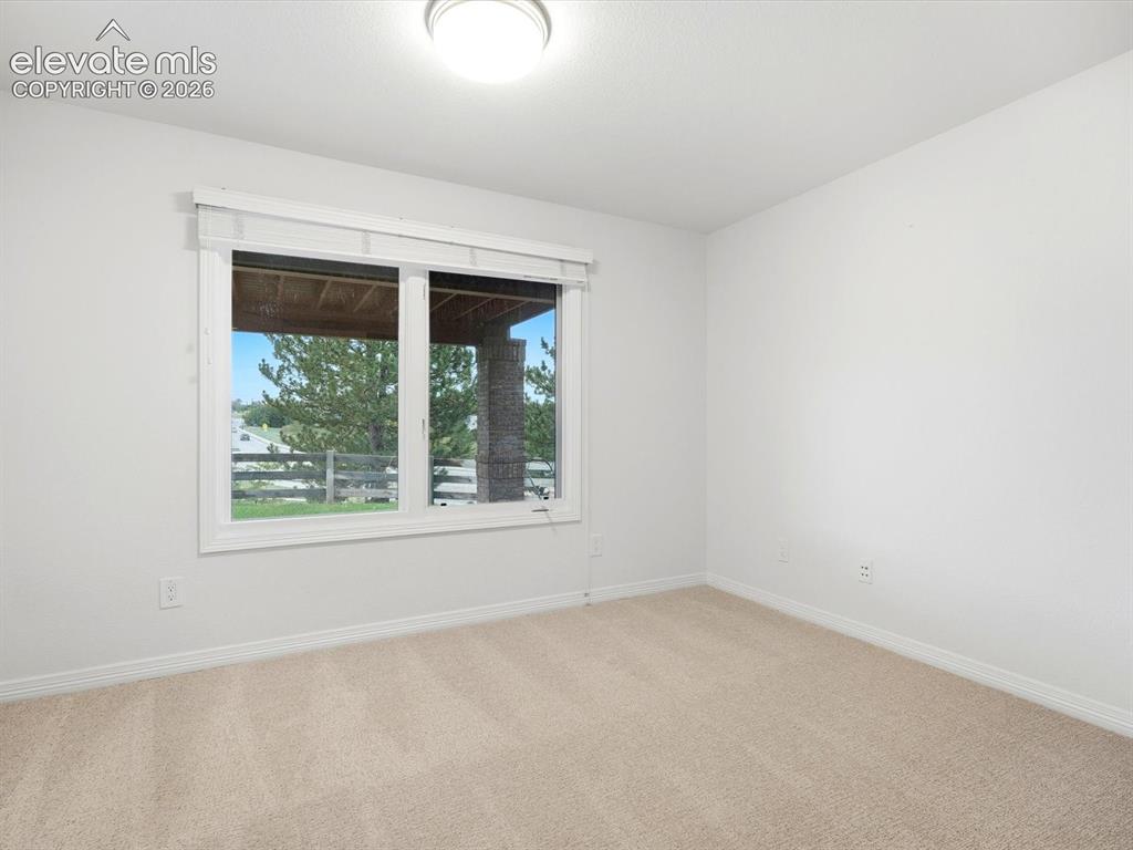Image 43 of 48: Neutral-toned wall-to-wall carpeting, window with white trim and integrated