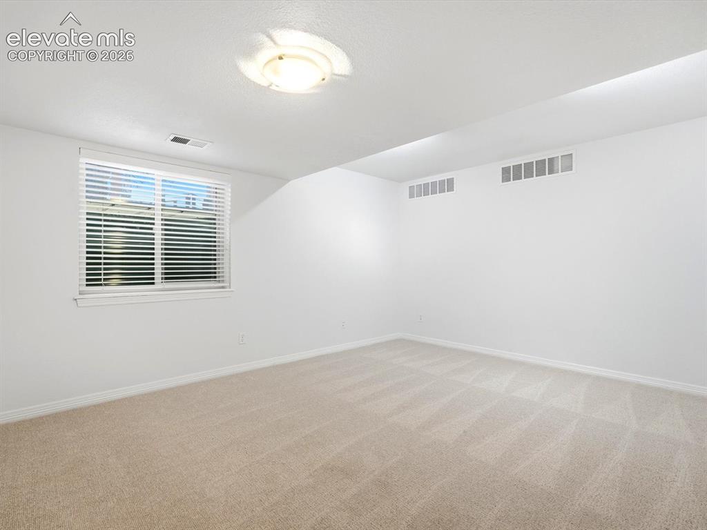 Image 44 of 48: Neutral-toned wall-to-wall carpeting, crisp white walls, and a recessed cei