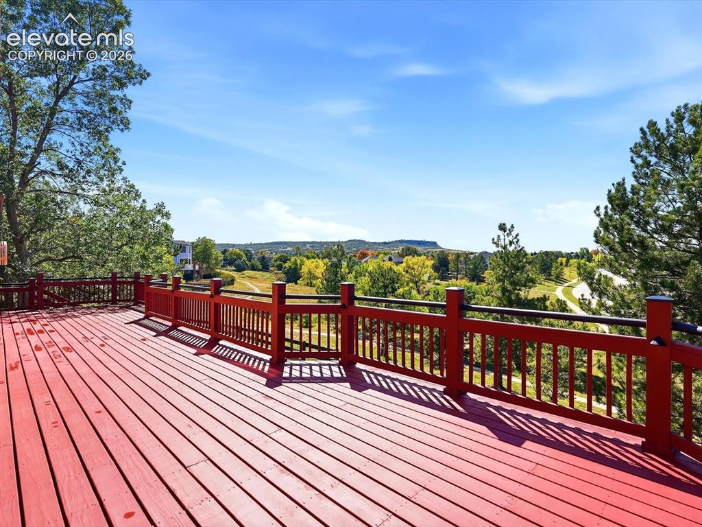 Image 45 of 48: Expansive wooden deck featuring horizontal railings and mesa landscape surr
