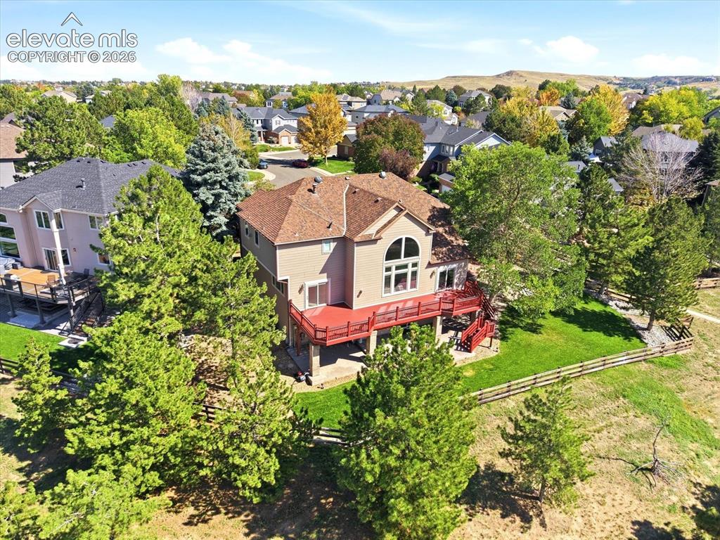 Image 47 of 48: Two-story residence featuring an elevated deck, ground-level patio, expansi