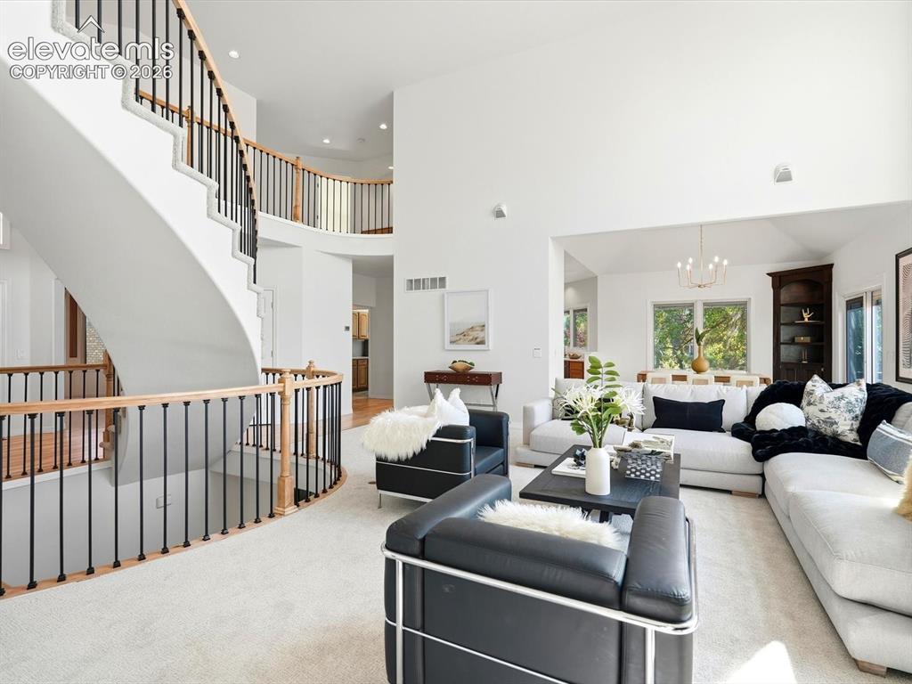 Image 6 of 48: Curved staircase featuring wood handrails and black metal balusters, soarin